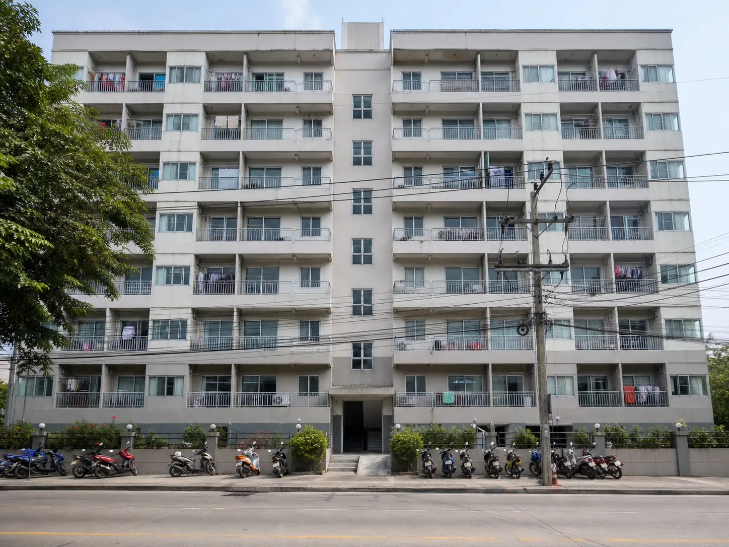 The eight-storey Ken's Place apartment building seen from the soi in mid-morning light