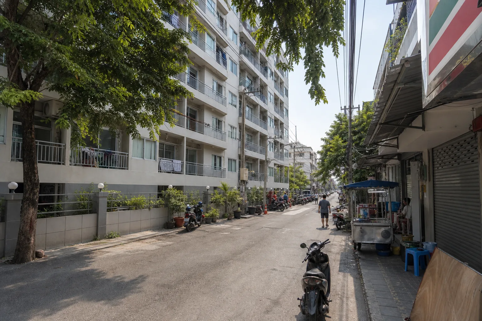 The side street outside the building in the afternoon, with shophouses and parked motorcycles